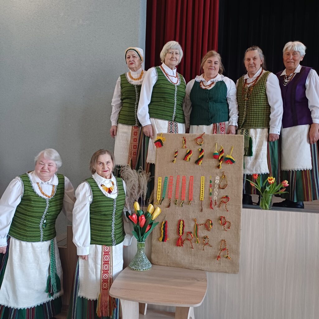 Saviveiklininkės prie trispalvio stendo